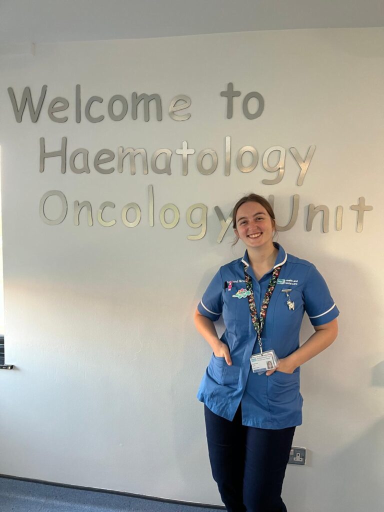 Nurse in blue uniform stands in hospital ward